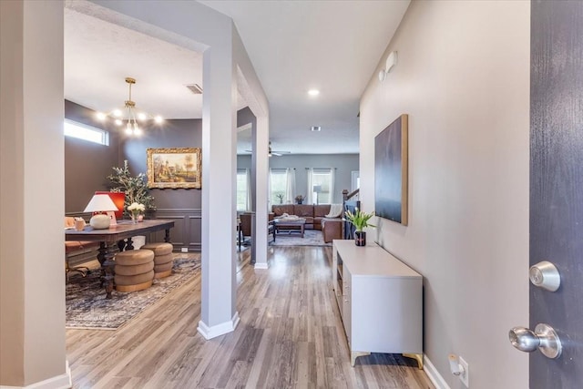 hall with light wood-style flooring and baseboards