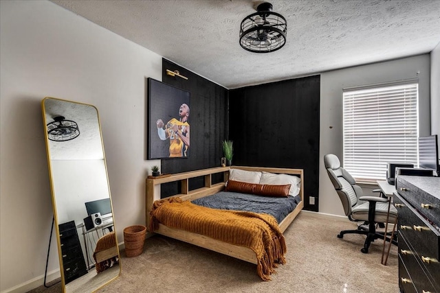 bedroom with carpet floors, an office area, a textured ceiling, and baseboards