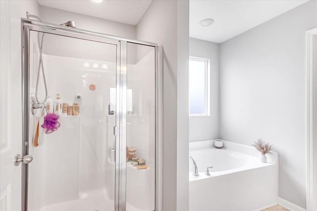 bathroom featuring a bath and a shower stall