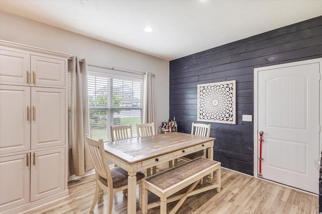 dining area featuring wooden walls, light wood-style flooring, and recessed lighting