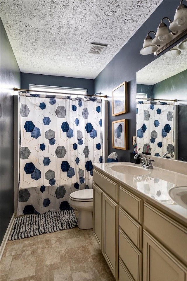 full bathroom with toilet, vanity, a textured ceiling, and curtained shower