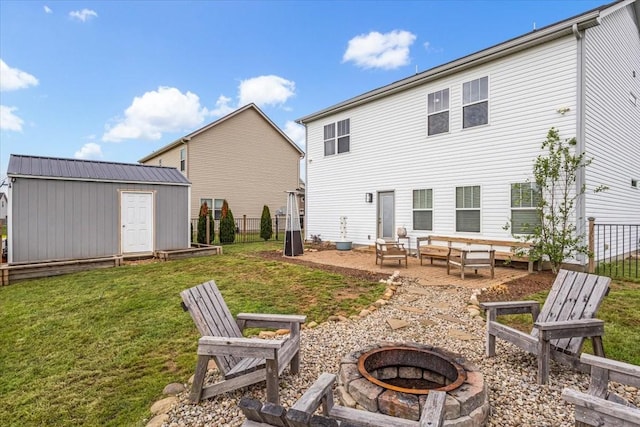 back of house featuring a fire pit, a shed, a patio, and an outdoor structure