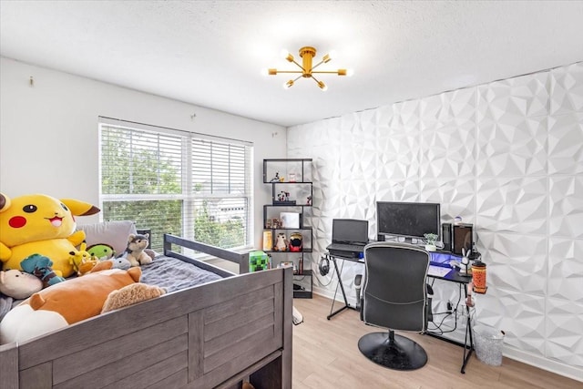 bedroom with light wood-type flooring, an office area, and baseboards