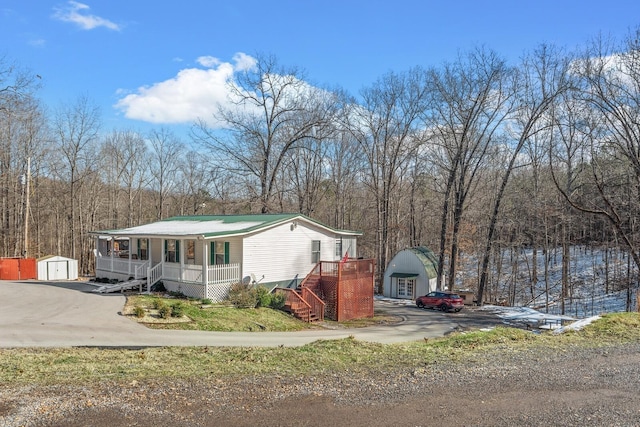 6966 Park Dr, Lyles, TN 37098 - view of front facade featuring a porch, a shed, an outbuilding, stairway, and a wooded view