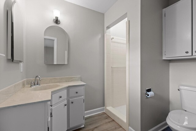 1511 Bunker Hill Dr, Chattanooga, TN 37421 - bathroom with wood finished floors, toilet, baseboards, tiled shower, and vanity