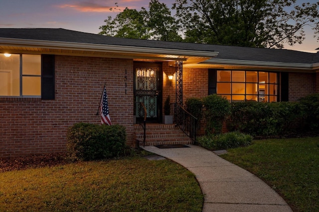 1511 Bunker Hill Dr, Chattanooga, TN 37421 - exterior entry at dusk featuring brick siding and a yard