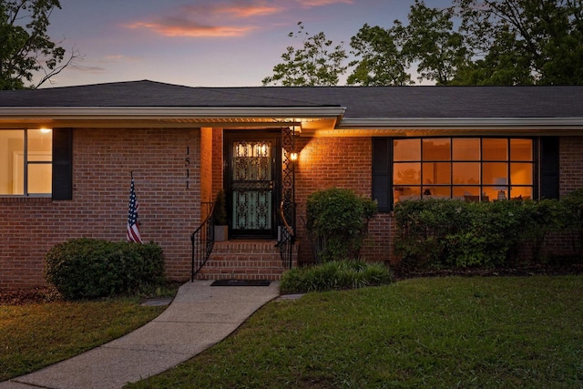 1511 Bunker Hill Dr, Chattanooga, TN 37421 - exterior entry at dusk with a yard and brick siding