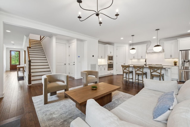 1022 Echelon Dr, Franklin, TN 37064 - living area featuring dark wood-style floors, recessed lighting, ornamental molding, a chandelier, and stairway