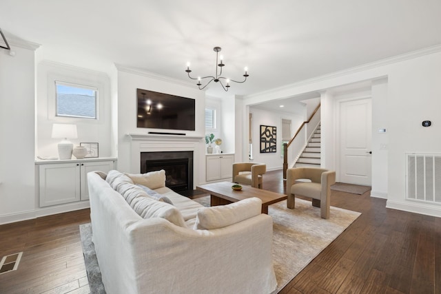 1022 Echelon Dr, Franklin, TN 37064 - living area featuring a chandelier, ornamental molding, dark wood-style floors, stairway, and a fireplace with flush hearth