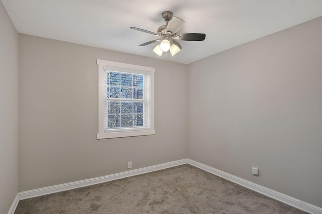 carpeted empty room featuring baseboards and a ceiling fan