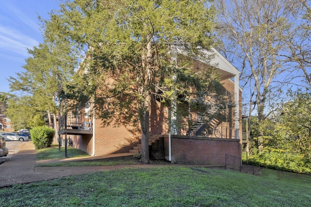rear view of house featuring brick siding and a yard