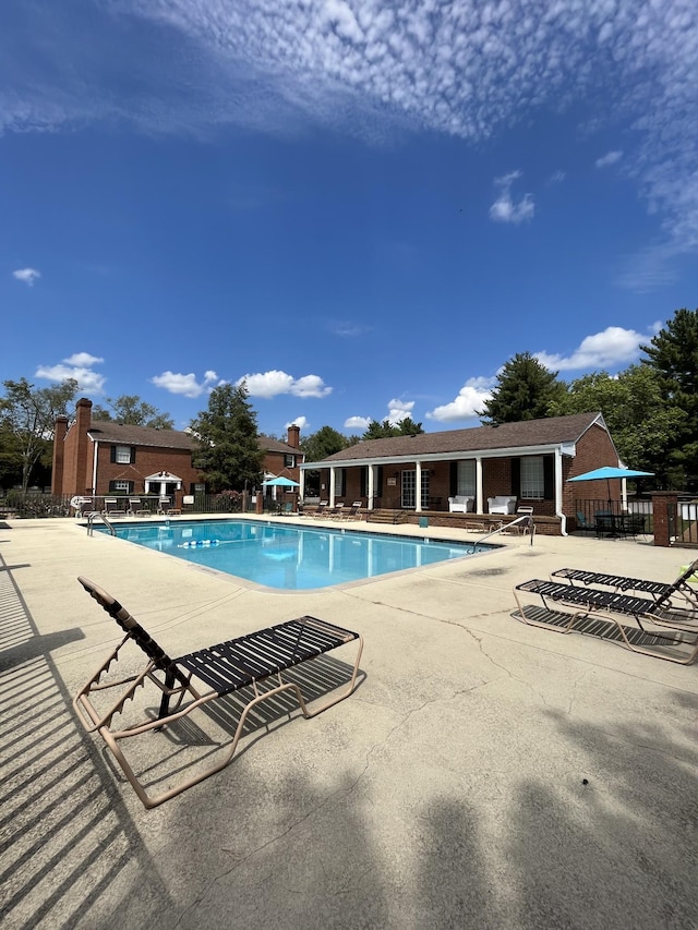 community pool with fence and a patio