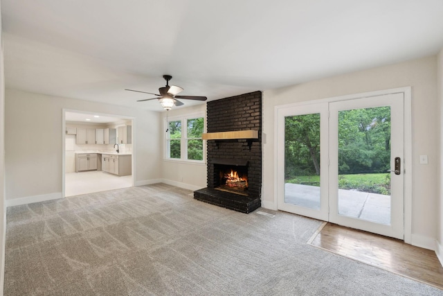 909 Plateau Pkwy, Nashville, TN 37205 - unfurnished living room with a brick fireplace, a ceiling fan, light colored carpet, and baseboards