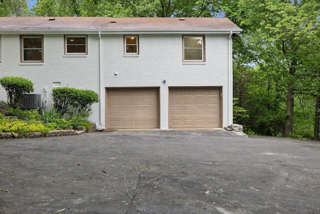 909 Plateau Pkwy, Nashville, TN 37205 - view of front facade with an attached garage, brick siding, central AC, and driveway
