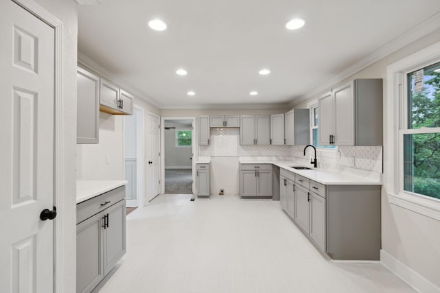 909 Plateau Pkwy, Nashville, TN 37205 - kitchen featuring gray cabinets, a sink, backsplash, plenty of natural light, and ornamental molding