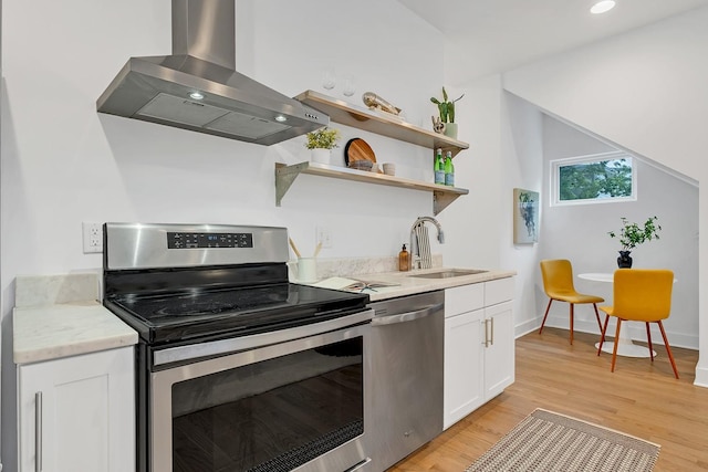 1056E 2nd Ave S, Nashville, TN 37210 - kitchen featuring appliances with stainless steel finishes, ventilation hood, a sink, light wood-style flooring, and white cabinetry