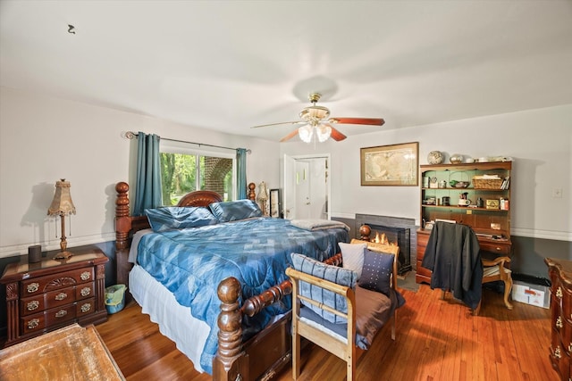 747 Hunting Creek Rd, Whitleyville, TN 38588 - bedroom featuring hardwood / wood-style flooring, a warm lit fireplace, and ceiling fan