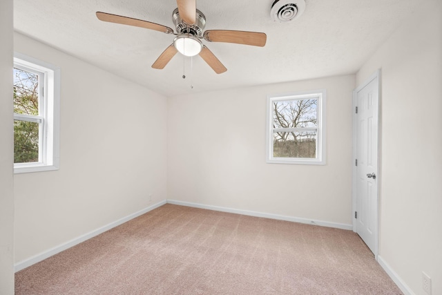 empty room with light colored carpet, baseboards, and ceiling fan
