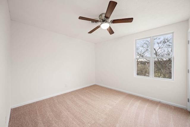 carpeted empty room with baseboards and a ceiling fan