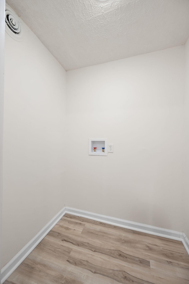 laundry area featuring hookup for a washing machine, light wood-style flooring, and baseboards