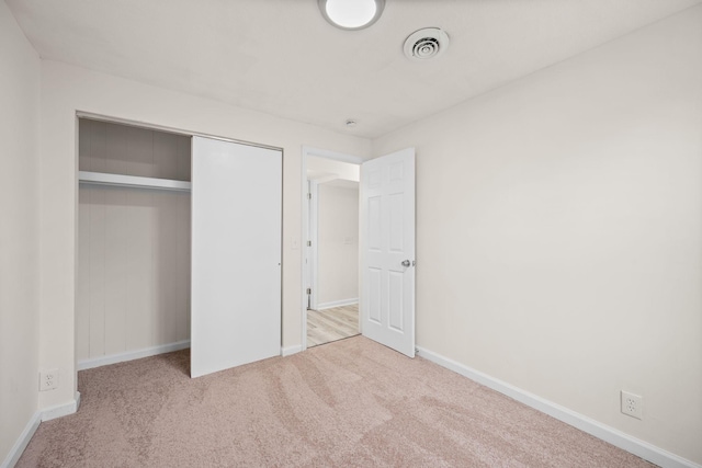 unfurnished bedroom with carpet, baseboards, and a closet