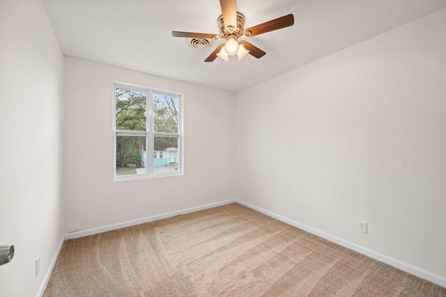 carpeted spare room with ceiling fan and baseboards