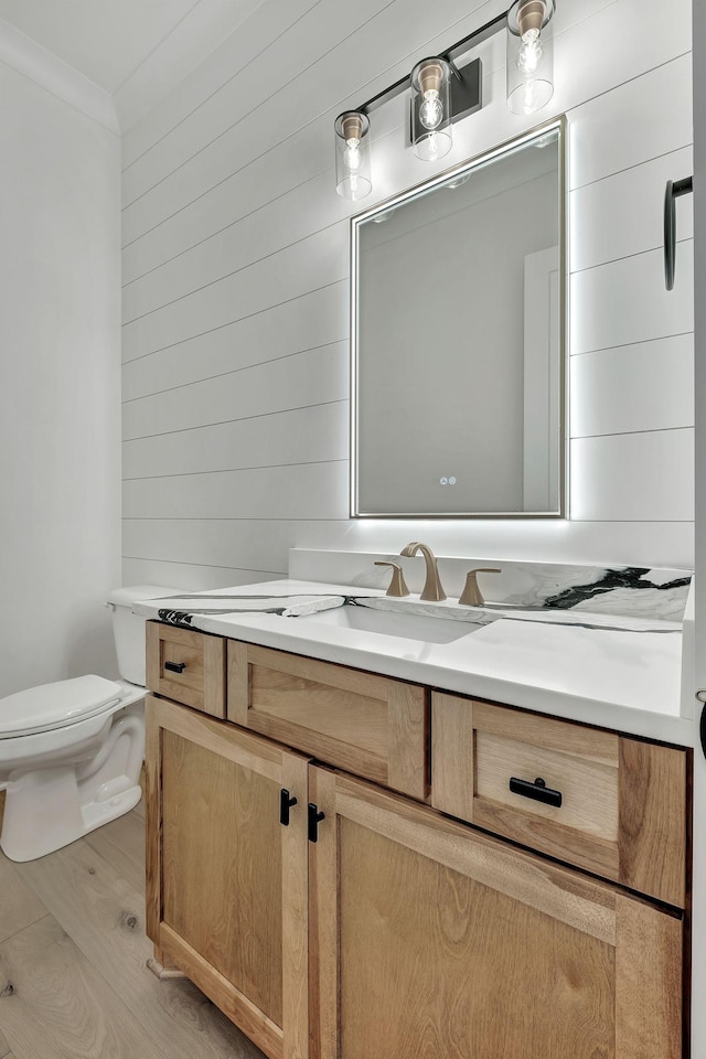 1018 Keeneland Dr, Gallatin, TN 37066 - half bath with vanity, toilet, wood finished floors, wooden walls, and crown molding