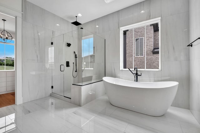 1018 Keeneland Dr, Gallatin, TN 37066 - bathroom with tile walls, a shower stall, a freestanding tub, and a chandelier