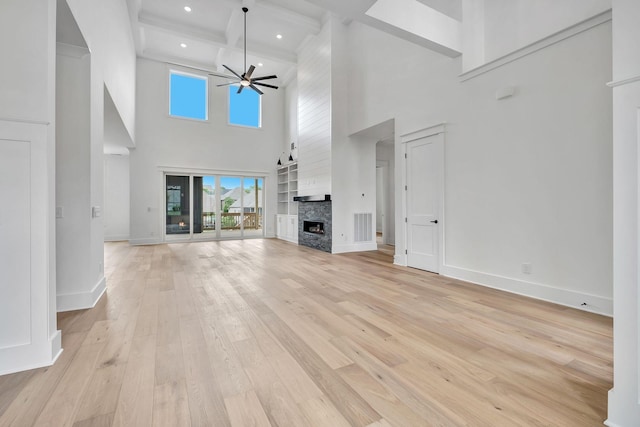 1018 Keeneland Dr, Gallatin, TN 37066 - unfurnished living room with a towering ceiling, a fireplace, light wood-style floors, baseboards, and a ceiling fan