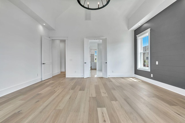 1018 Keeneland Dr, Gallatin, TN 37066 - unfurnished bedroom featuring light wood-type flooring, baseboards, a high ceiling, and a chandelier