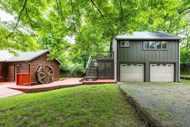 view of yard featuring a deck, stairway, and driveway