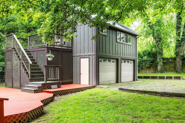 rear view of property with board and batten siding, a wooden deck, stairs, and an attached garage