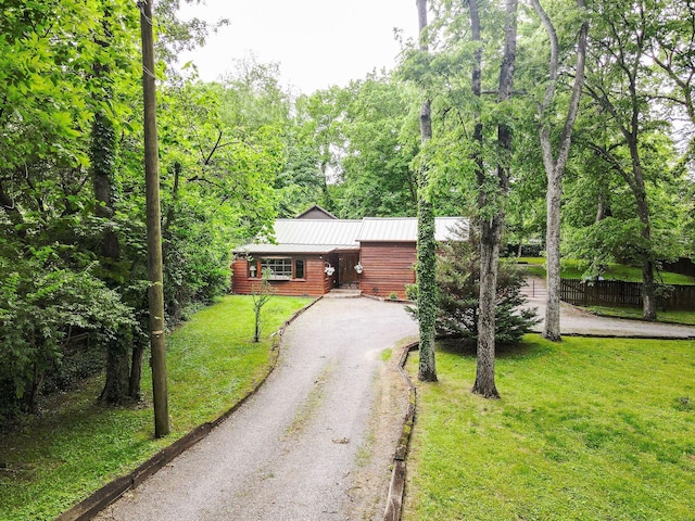 log cabin with asphalt driveway and metal roof