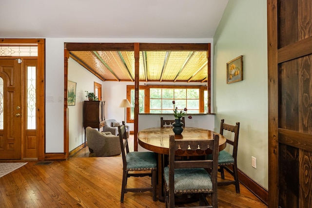 dining space with hardwood / wood-style flooring and baseboards