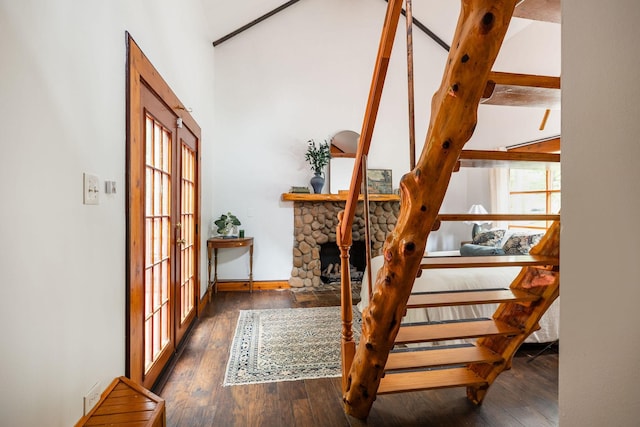 stairway featuring wood finished floors, lofted ceiling, baseboards, and french doors