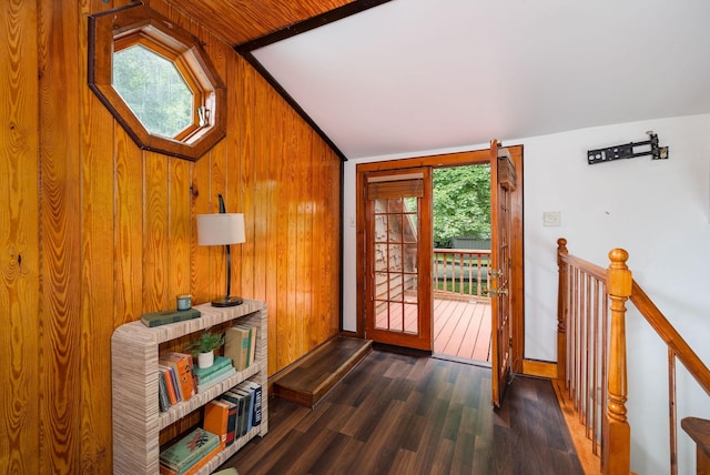 doorway with wood walls, wood finished floors, and baseboards