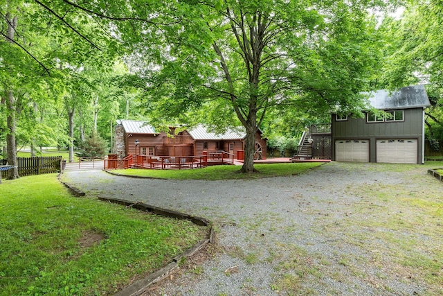view of yard with stairs, a garage, and gravel driveway