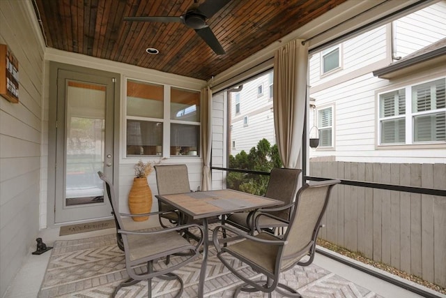 sunroom / solarium with a ceiling fan and outdoor dining area