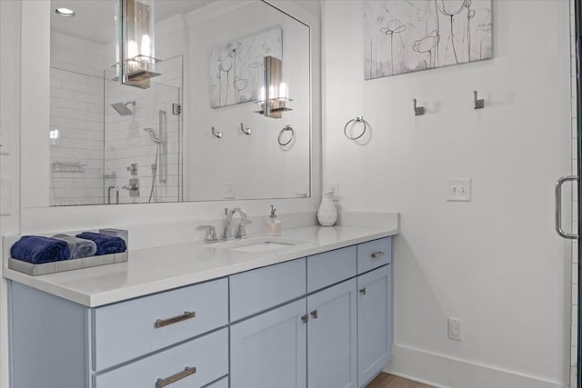 full bathroom with a shower stall, vanity, and baseboards