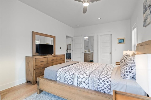 bedroom with wood finished floors, baseboards, ensuite bathroom, and a ceiling fan