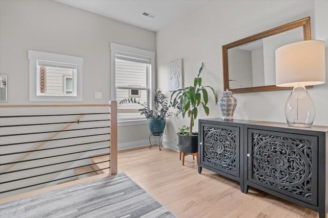 hallway with wood finished floors, plenty of natural light, and baseboards