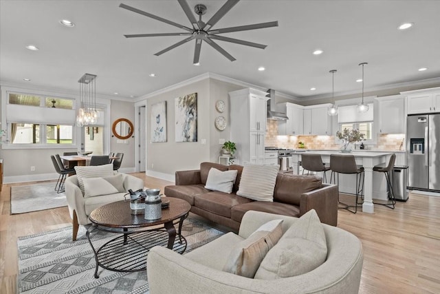 living area featuring ceiling fan, baseboards, crown molding, light wood-style flooring, and recessed lighting