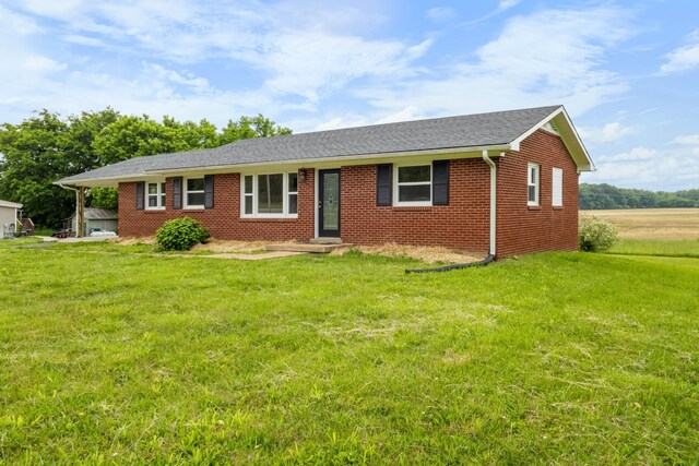 ranch-style home featuring a front yard, brick siding, and a shingled roof