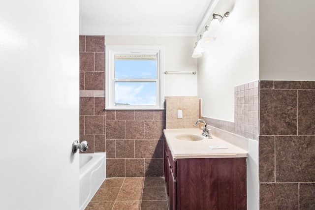 full bath with tile walls, vanity, crown molding, a bathtub, and tile patterned floors