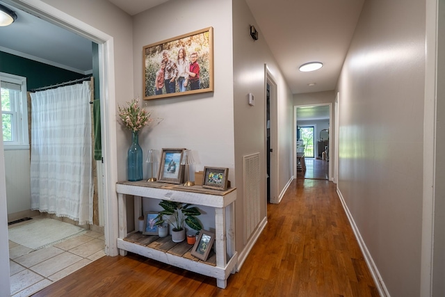 hallway with wood finished floors and baseboards