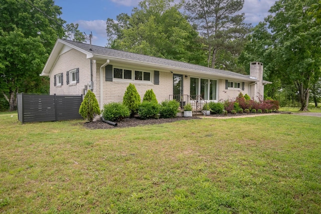ranch-style home with a front lawn and a chimney
