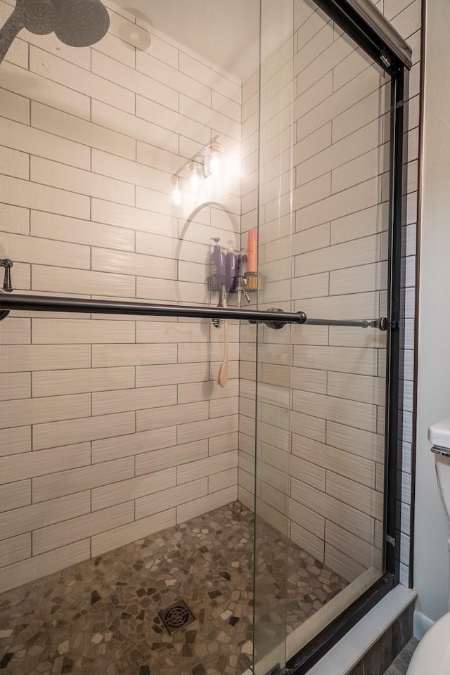 bathroom with toilet and a stall shower