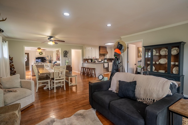 living area featuring a ceiling fan, wood finished floors, crown molding, and recessed lighting