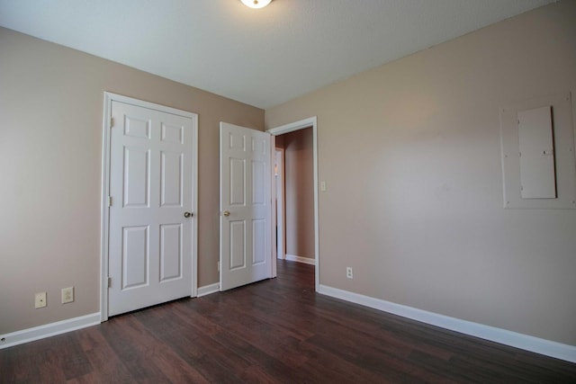 587 Joshua Dr, Clarksville, TN 37042 - unfurnished bedroom featuring electric panel, dark wood-type flooring, and baseboards