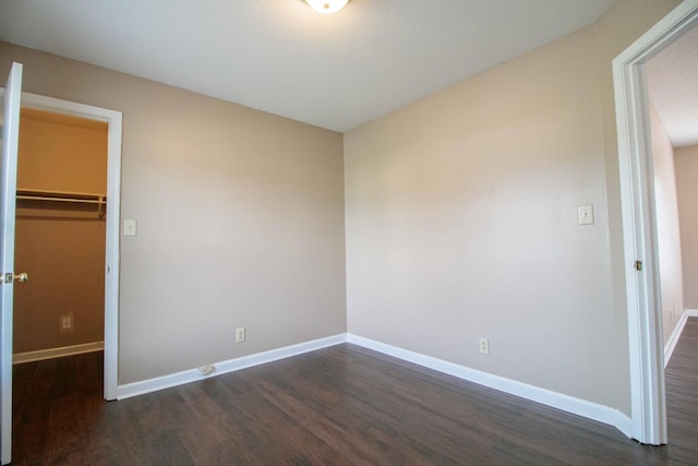 587 Joshua Dr, Clarksville, TN 37042 - unfurnished bedroom with dark wood finished floors, a spacious closet, baseboards, and a closet